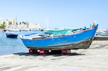 Naklejka na ściany i meble Blue boat on the beach of Bari, Italy