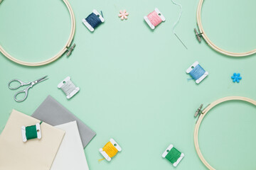 Embroidery set fot stitching on green background with embroidery hoop, fabric, colorful threads,...