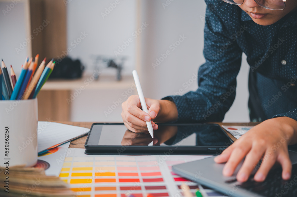 Fototapete Graphic designer architects who work with laptops and color comparison tables for design work..