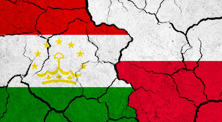 Flags of Tajikistan and Poland on cracked surface - politics, relationship concept