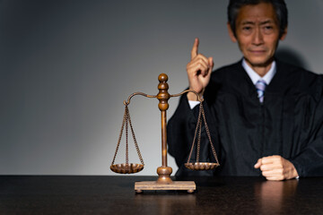 法服を着た男性と天秤　司法イメージ
