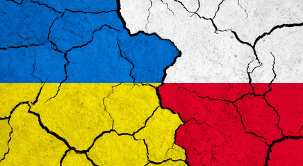 Flags of Ukraine and Poland on cracked surface - politics, relationship concept
