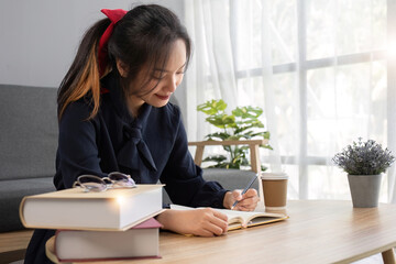 Close up young woman of Asian write down memories in notebook diary, work homework