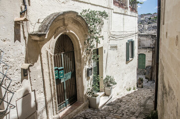 Old street in Matera with green doors and windows