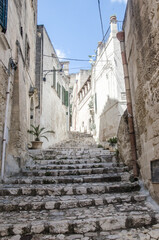 Narrow street with upstairs and flowers in Matera, Puglia, Italy.