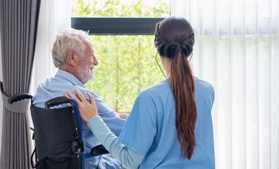 The wheelchair-bound man. He observes a window in a hospital with a patient bed.lonesome crippled person. Patient and depression in a photograph.