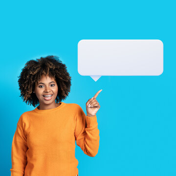Happy african american woman pointing upwards at blank comminication bubble