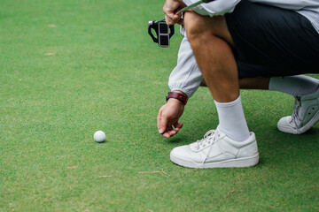 Golfer using pin marking position of golf ball on green