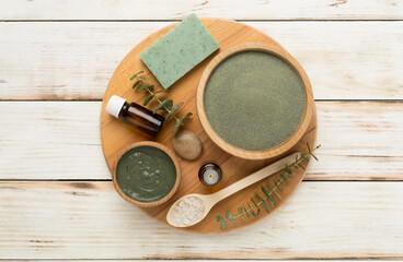 Composition with cosmetic clay and spa products on wooden background, top view