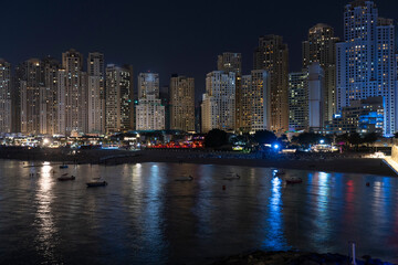 View of the skyline of Marina dubai with business and residential towers and the Marina beach illuminated at night, Dubai, UAE