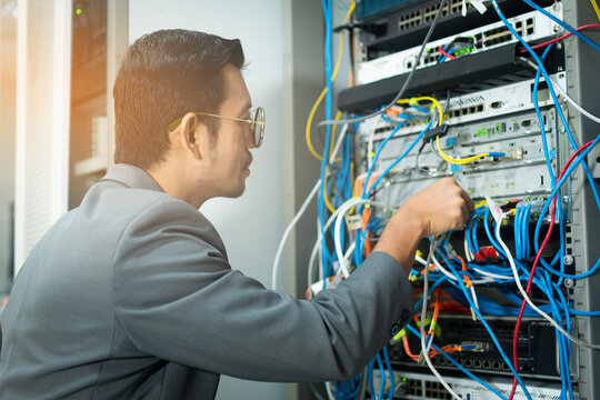 IT technician checking the network connection in server room for maintenance