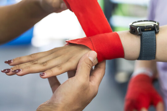 close up of boxing trainer hands wrapping boxer with sport bandage