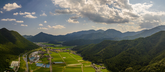 Panoramic aerial view of lush rice farms in mountain valley landscape
