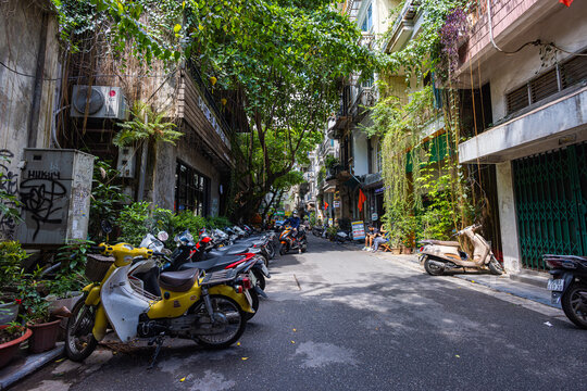Hanoi, Vietnam - May 28, 2023: Enchanting Old town streets reveal a vibrant tableau: motorcycles and bicycles whizzing by, creating a melodic cacophony. This energetic scene showcases Vietnam culture