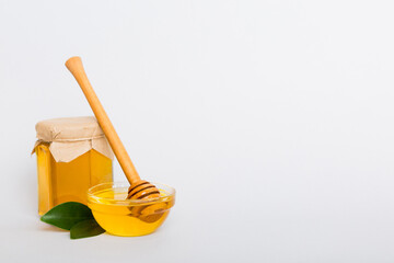 Honey in jar with leaves and honey dipper on colored background top view with copy text