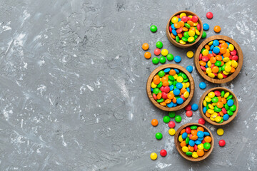 different colored round candy in bowl and jars. Top view of large variety sweets and candies with copy space