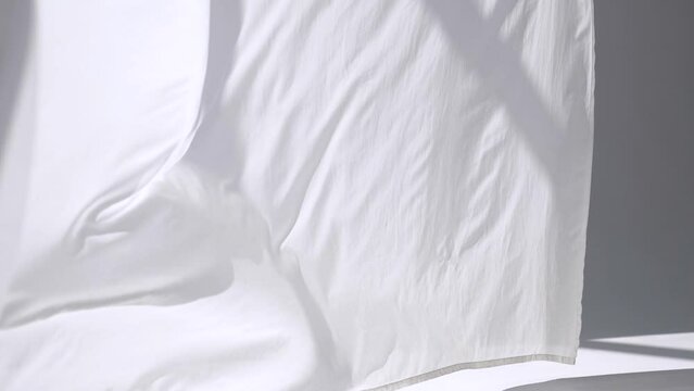White transparent fabric flutters in the wind. Long white curtains in a bright studio. slow motion