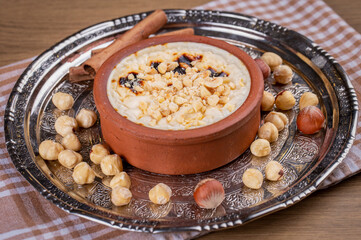 Baked rice pudding turkish milky dessert sutlac in earthenware casserole with hazelnuts