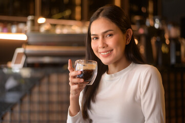 A young woman drinking coffee in modern coffee shop