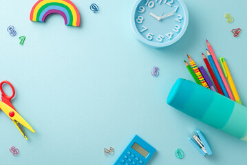 Top view of desk arranged with drawing supplies: stationery, pencil case, pens, rainbow plasticine,...