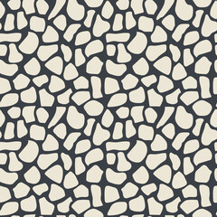 White abstract spots on black. Modern shapeless polka dots form a seamless pattern for textiles, decorative paper. 