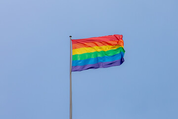 Celebration of pride month, Colourful rainbow flag waving in the air with blue clear sky background, The symbol of Gay, Lesbian, Bisexual and Transgender, LGBTQ community, Worldwide social movements.
