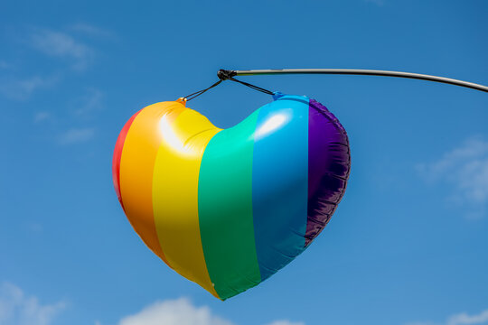 Celebration of pride month, Colourful rainbow heart shaped balloon with blue clear sky as background, The symbol of Gay, Lesbian, Bisexual and Transgender, LGBTQ community, Worldwide social movements. - Powered by Adobe