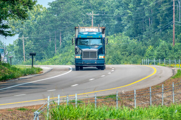 Heavy Truck Negotiates Curve On Rural Blacktop Road
