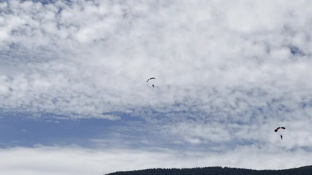 Aerial video of people skydiving high in the sky on a sunny day
