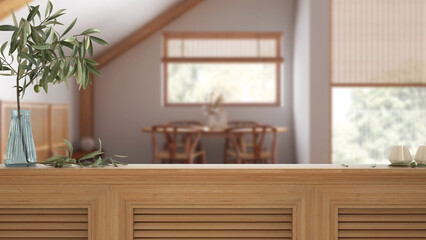 Wooden table top, cabinet, panel or shelf with shutters close up. Olive branch in vase and candles. Blurred background with farmhouse dining room, japandi interior design