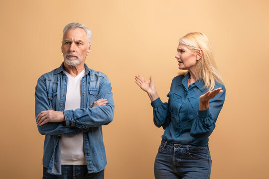 Angry senior woman wife scolding her frustrated husband