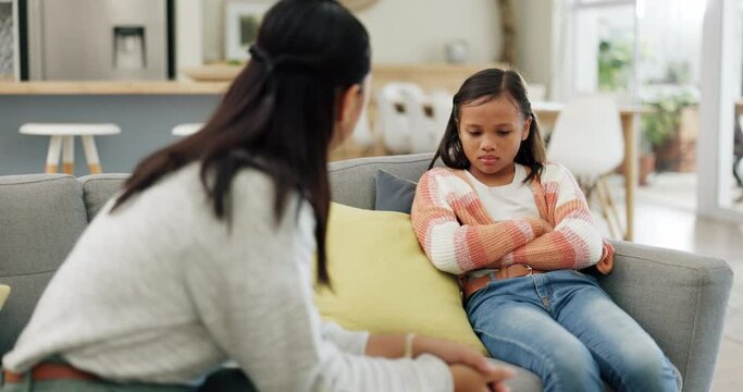 Mother, child and talking at home about discipline, bad behaviour or psychology problem on a sofa. A woman or psychiatrist with a upset girl kid in a living room for discussion, advice or support