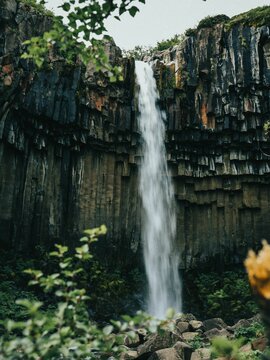 Beautiful shot of the picturesque flowing Svartifoss waterfall in Iceland © João Silva/Wirestock Creators