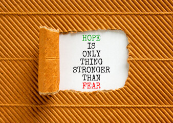 Hope stronger than fear symbol. Concept words Hope is the only thing stronger than fear on beautiful white paper on a beautiful brown background. Business motivational hope stronger than fear concept.