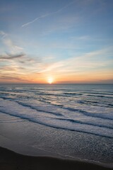 Fototapeta na wymiar Scenic view of the waves splashing on the sandy beach at sunset