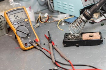 Closeup of a soldering iron and electrical measuring instrument