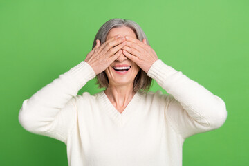 Photo of retired funny grey hair lady cover eyes closed laughing joking carefree peekaboo playing isolated on green color background