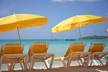 Scenic view of beach chairs with umbrellas on a sandy beach on a sunny day