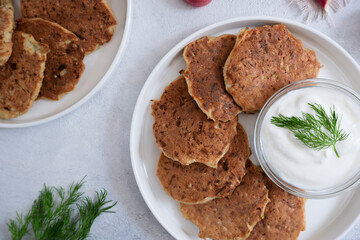 Zucchini pancakes with sour cream and herbs. Vegetarian food, proper nutrition.