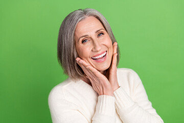 Photo of gorgeous lady pensioner middle age hands touch cheeks laughing enjoy her new face lotion...