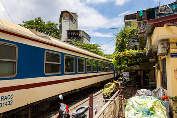 Hanoi, Vietnam - May 28, 2023: Train Street in Hanoi is a narrow, bustling lane with tracks. Close knit houses, adorned with plants, are inches away from passing trains. bars and cafes line the track