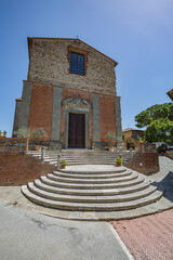 Lucignano, Italy - 23 of May 2022: Walking streets small historic town Lucignano in Tuscany, Italy. View of church "Collegiata di San Michele Arcangelo" facade.