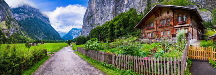  Switzerland travel . most scenic places. beautiful Lauterbrunnen village with traditional wooden houses and valley surrounded by impressive Alps mountains and waterfalls © Freesurf