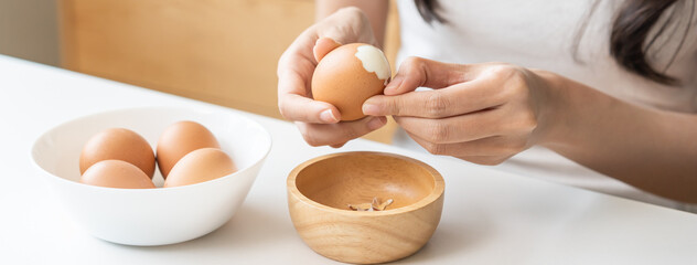 Protein in food, keto diet asian young woman hand peeling, shelling chicken boiled egg, prepares...