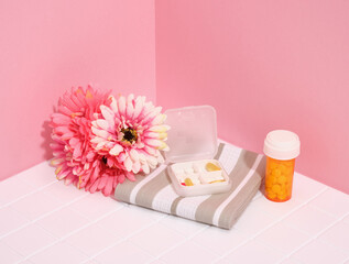 The pills and vitamins in the container lie on a clean towel. Healthcare and medicine.