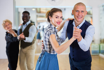 Man and woman performing ballroom dance in dancing room - obrazy, fototapety, plakaty