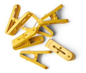 pile of yellow clips, plastic paper or laundry clips, clothespin or clothes pegs isolated on white background taken straight from above