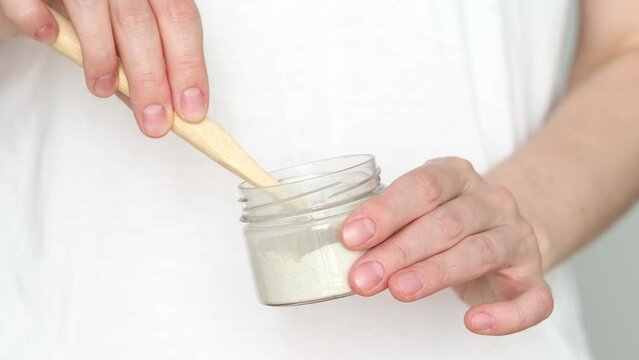 A woman is holding a bamboo toothbrush and tooth powder. The concept of zero waste and eco-friendly products. Natural and eco-friendly cosmetics for the oral cavity. Organic Tooth Cleaning Powder