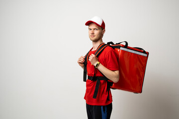 Delivery employee man in red uniform with athermal food bag backpack work as a courier.