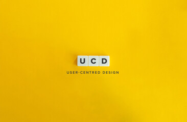 UCD Initialism for User-Centred Design (UX Design). Letter Tiles on Bright Orange Background.